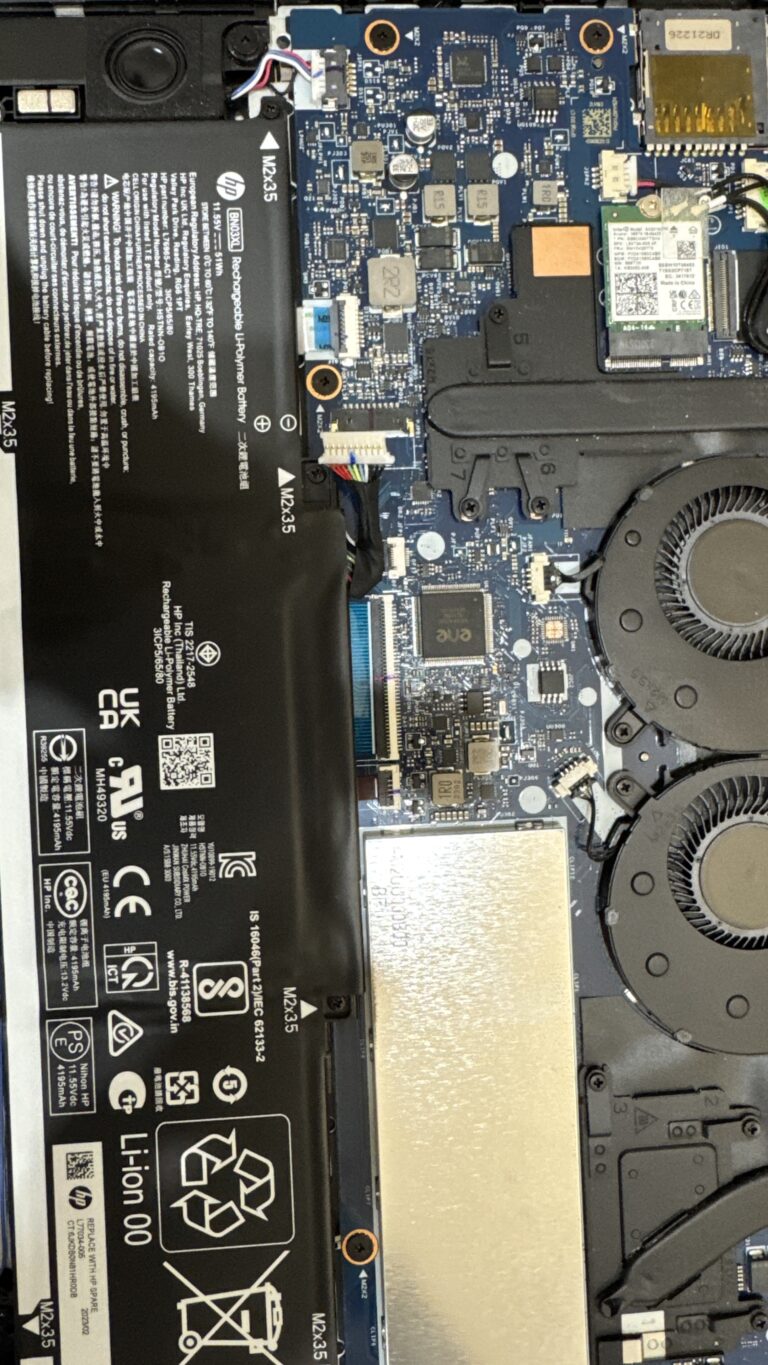 Laptop opened showing battery and motherboard